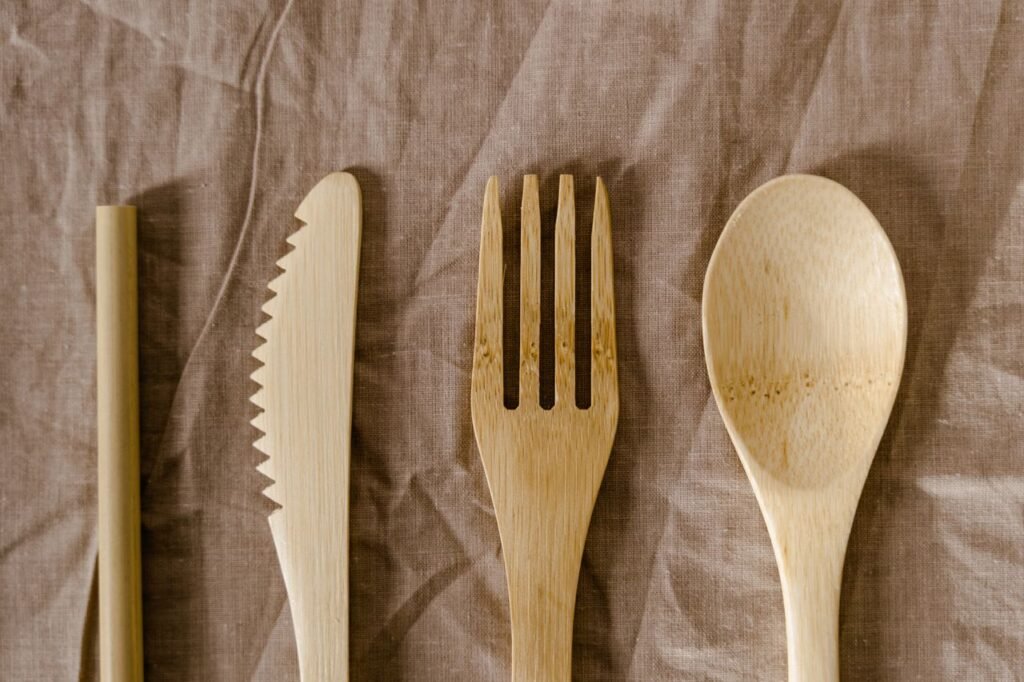 Reusable bamboo cutlery set on linen, promoting sustainable living.